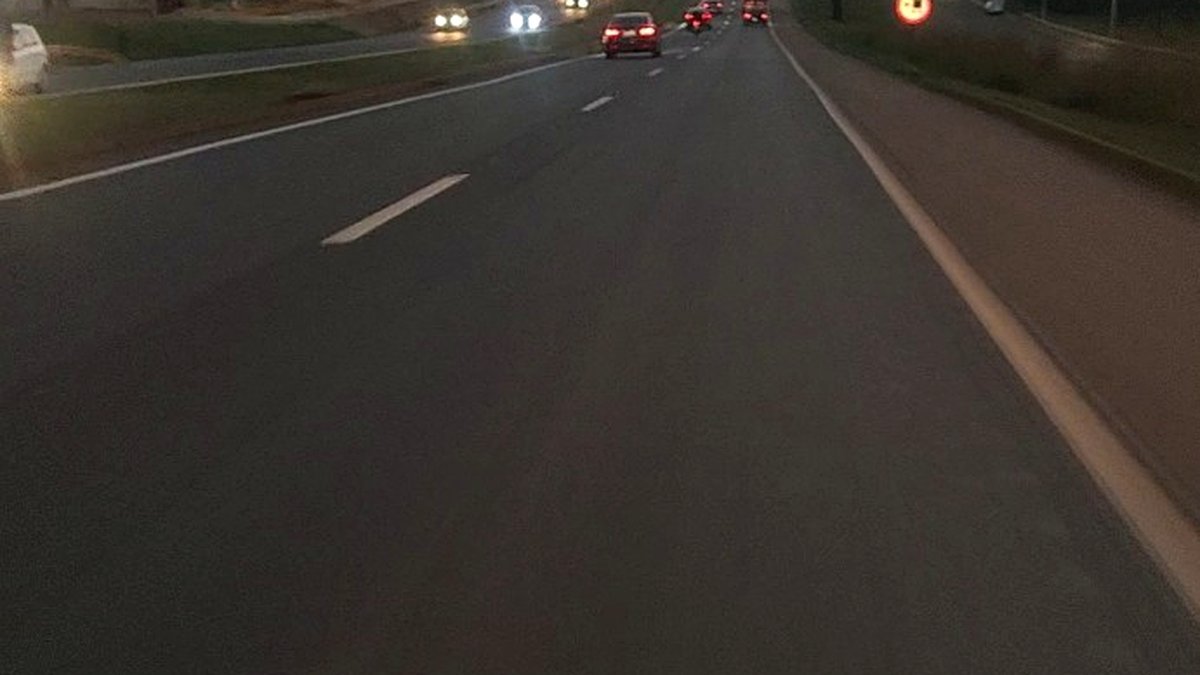 Avenida no fim da tarde enquanto a vida segue seu caminho